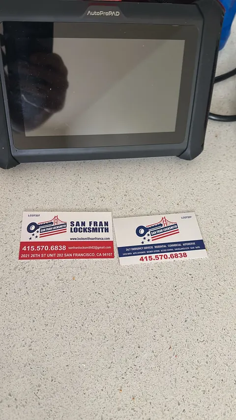 The programming tablet set down on a car with the company's cards beside it.